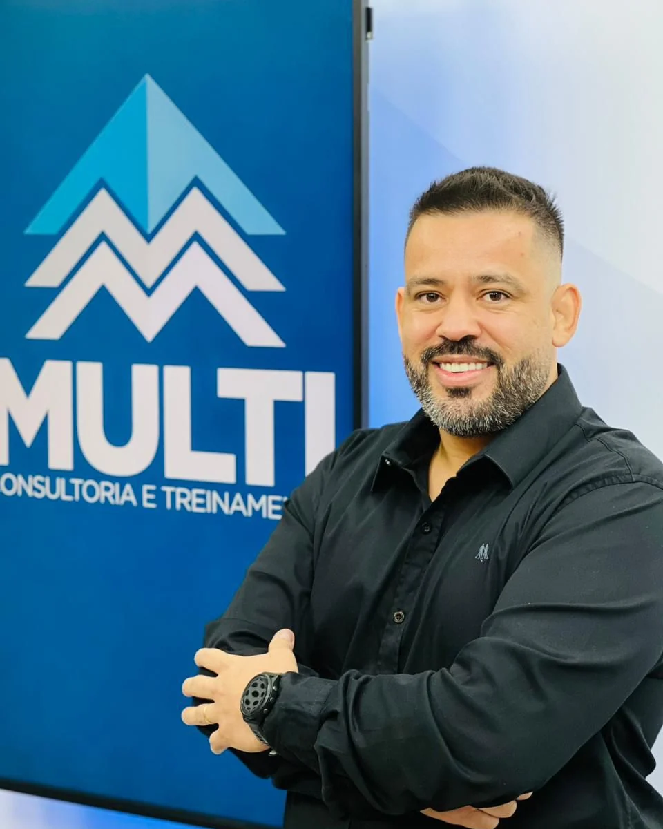 Diego Ferreira na frente do painel da Multi Consultoria e Treinamento